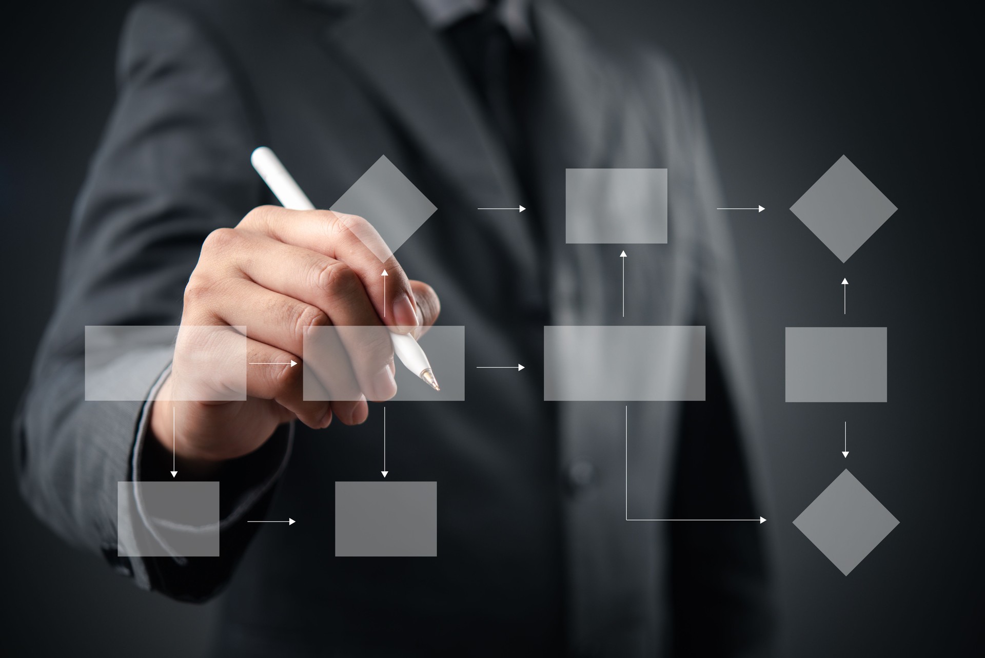 Businessman drawing a digital flowchart with a pen, illustrating the concept of process management and decision-making in the modern workplace.